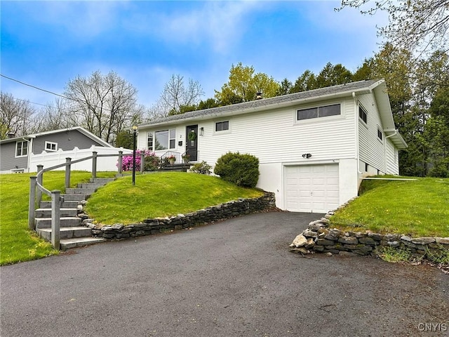single story home featuring a front lawn, driveway, and an attached garage