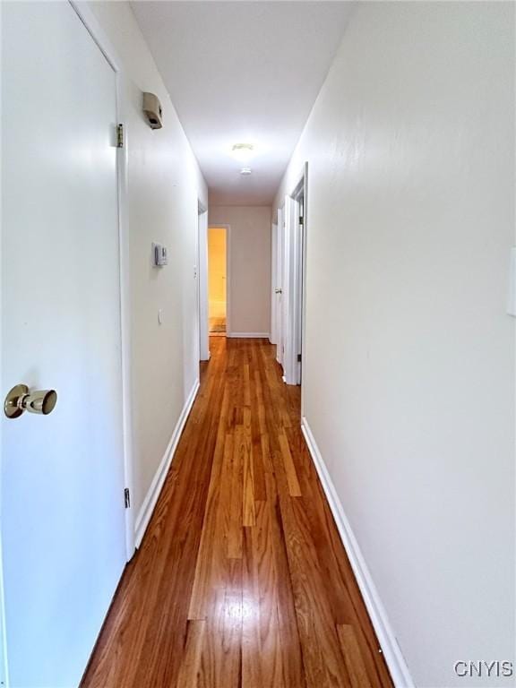hallway with baseboards and wood finished floors