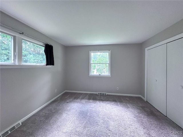 unfurnished bedroom featuring carpet, baseboards, and visible vents