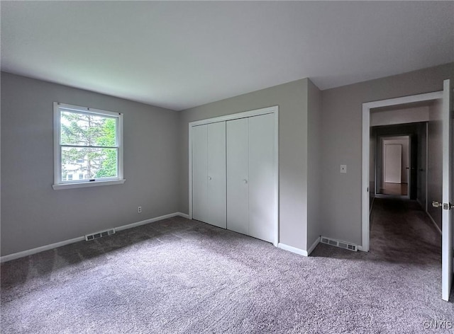 unfurnished bedroom featuring a closet, visible vents, baseboards, and carpet floors