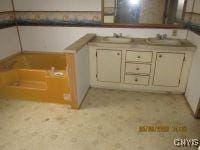 111 Maple Ave, Augusta, NY 13425 - bathroom featuring double vanity, a garden tub, and a sink