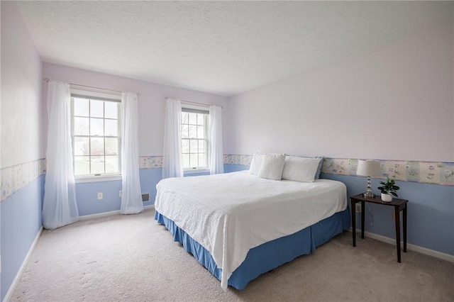 carpeted bedroom with a textured ceiling and baseboards