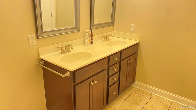 bathroom with a sink, tile patterned flooring, double vanity, and baseboards