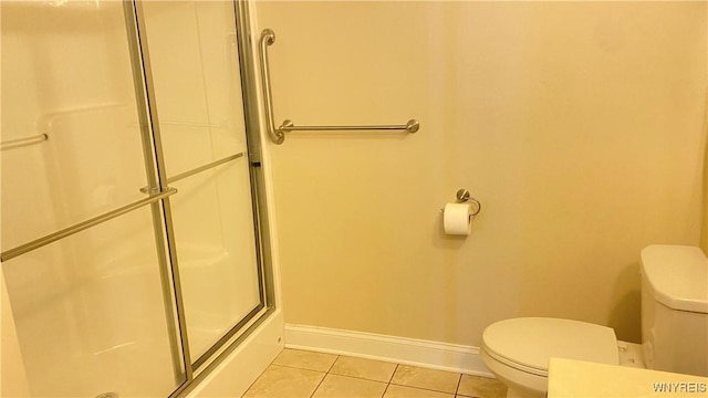 bathroom featuring toilet, baseboards, tile patterned floors, and a shower with door