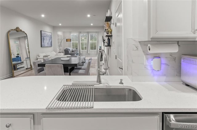 177 Sandstone Cir, Grand Island, NY 14072 - kitchen with light stone counters, a sink, white cabinets, open floor plan, and tasteful backsplash