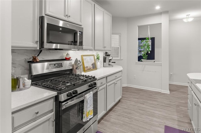 177 Sandstone Cir, Grand Island, NY 14072 - kitchen featuring baseboards, light wood-style floors, stainless steel appliances, and decorative backsplash