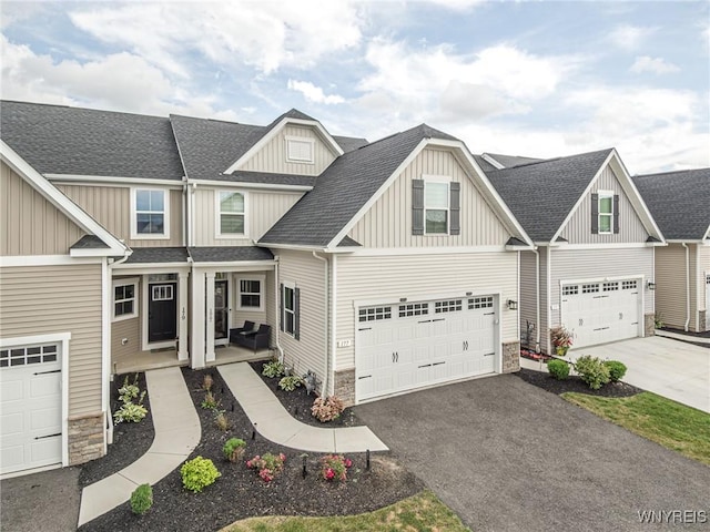 177 Sandstone Cir, Grand Island, NY 14072 - craftsman house with stone siding, a garage, aphalt driveway, a shingled roof, and board and batten siding