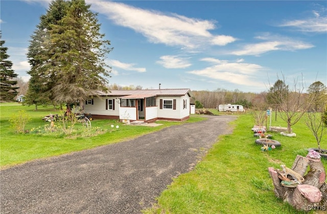 87 Kings Rd, Volney, NY 13069 - view of front of home featuring metal roof, a front yard, and driveway
