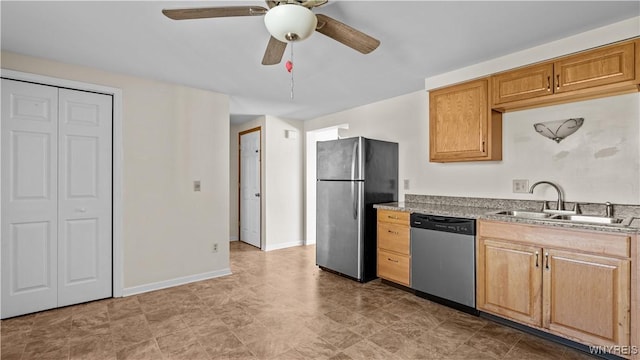 kitchen with a sink, baseboards, light stone countertops, ceiling fan, and appliances with stainless steel finishes