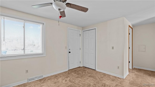 interior space featuring baseboards, a ceiling fan, visible vents, and a closet