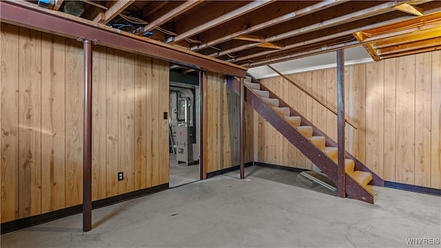 basement featuring wooden walls and stairs