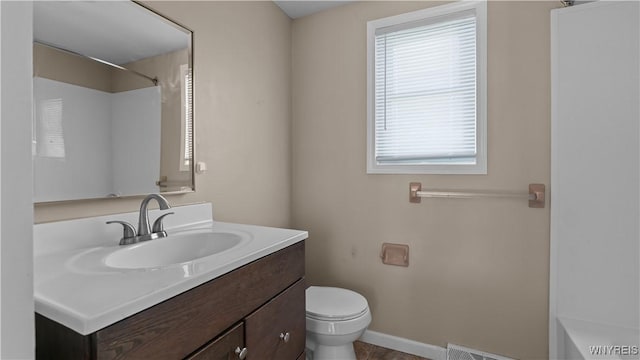 full bath with toilet, baseboards, and vanity
