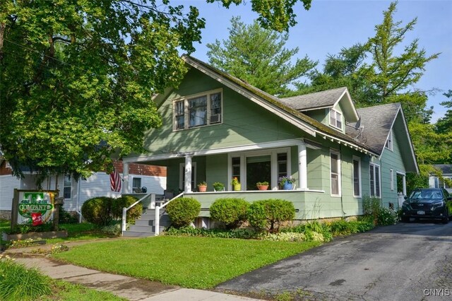 18 Crossmon St, Alexandria, NY 13607 - bungalow-style house featuring a shingled roof, a porch, driveway, and a front yard