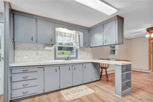 9862 Rte 219, Ashford, NY 14171 - kitchen featuring a peninsula, backsplash, gray cabinets, and a sink