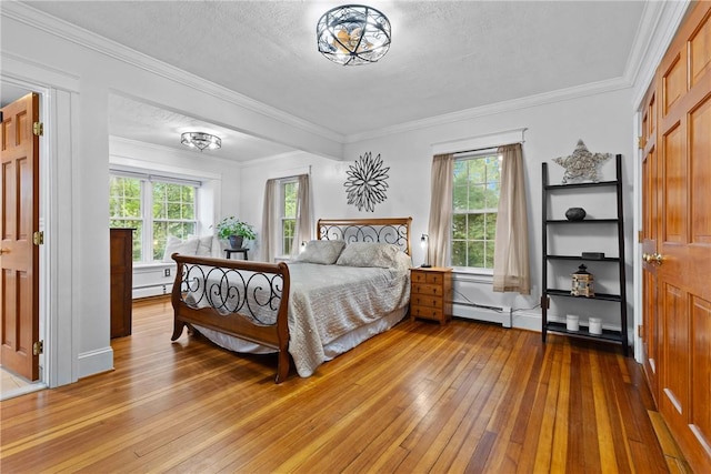 bedroom with crown molding, a textured ceiling, light wood-type flooring, and baseboard heating
