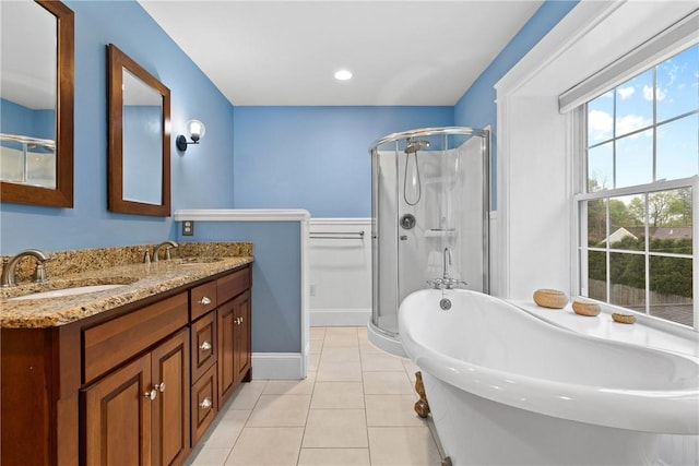 bathroom featuring a soaking tub, tile patterned floors, a shower stall, and a sink