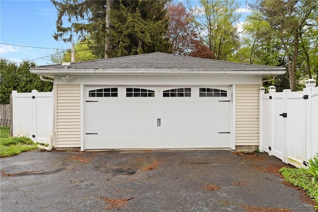 detached garage featuring a gate and fence