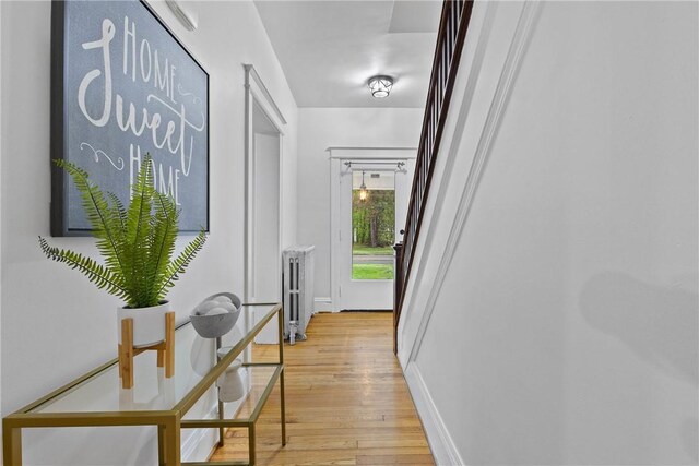 corridor with baseboards and light wood-style floors