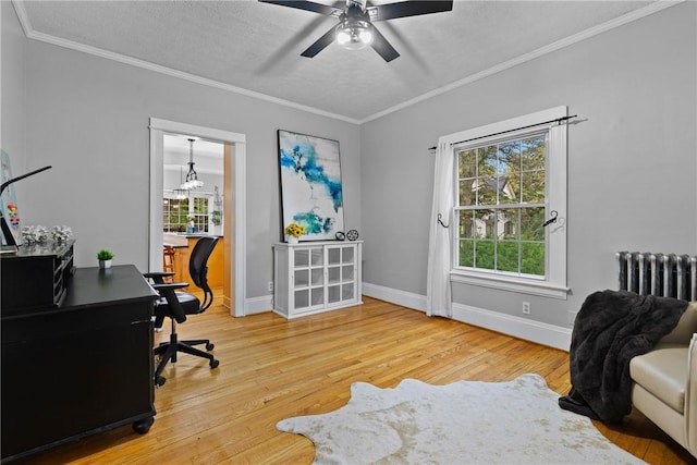 office area featuring hardwood / wood-style flooring, radiator, ornamental molding, a ceiling fan, and baseboards