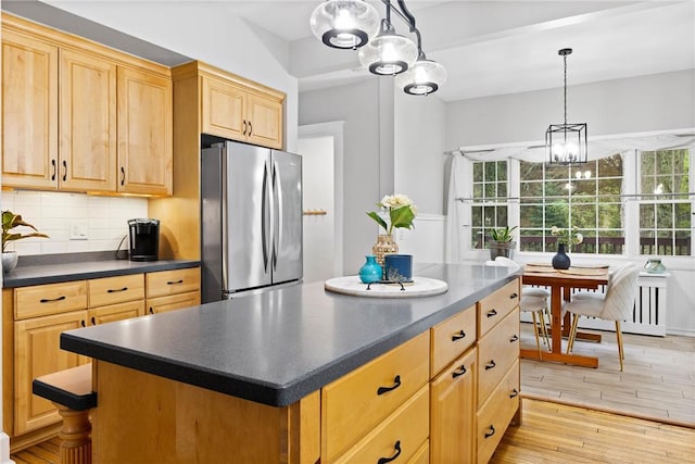 kitchen with freestanding refrigerator, dark countertops, light wood-style flooring, and a notable chandelier
