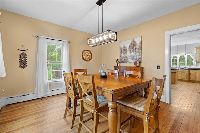 dining room featuring light wood-type flooring and a notable chandelier