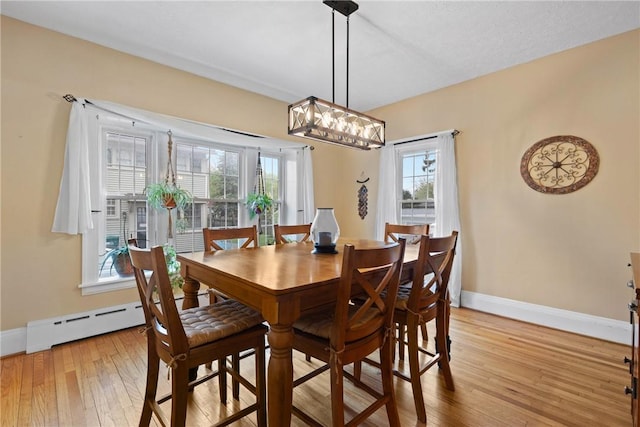 dining space featuring baseboards, light wood finished floors, and plenty of natural light