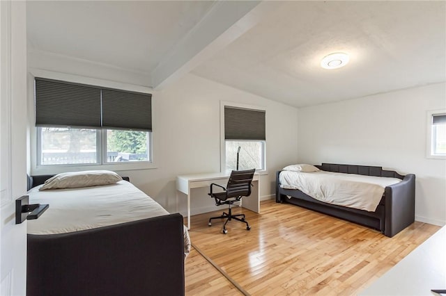 bedroom with baseboards, wood finished floors, and lofted ceiling with beams