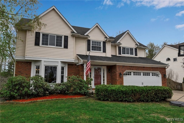 traditional home featuring an attached garage, fence, a front yard, brick siding, and driveway