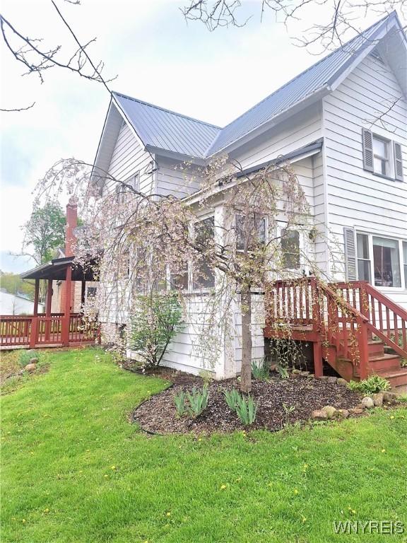 49 Grove St, Warsaw, NY 14569 - view of home's exterior featuring metal roof and a lawn
