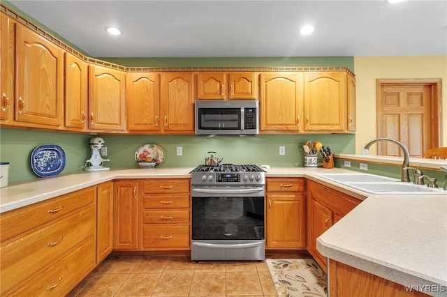kitchen featuring stainless steel appliances, recessed lighting, light tile patterned flooring, a sink, and light countertops