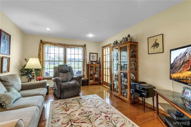 living area with baseboards, french doors, recessed lighting, and wood finished floors
