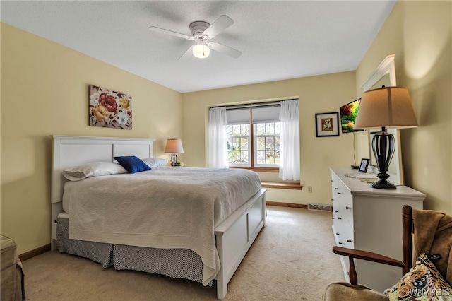 bedroom with light colored carpet, baseboards, ceiling fan, and visible vents