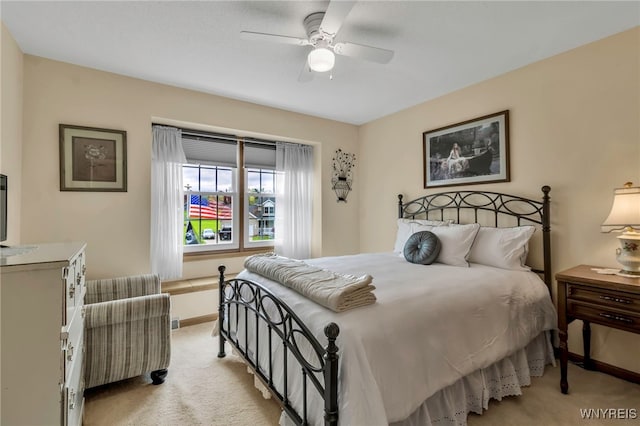 bedroom with light carpet, baseboards, and a ceiling fan