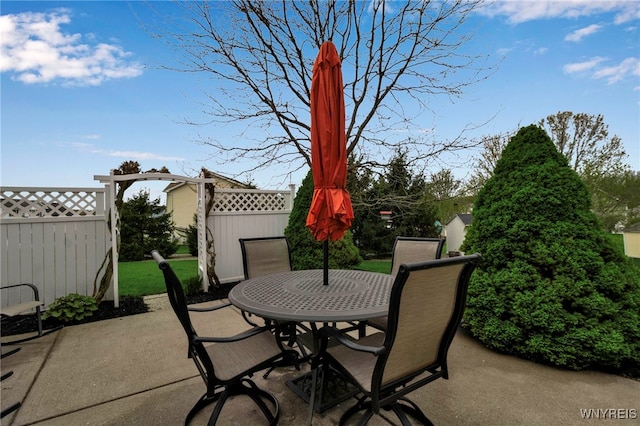 view of patio featuring outdoor dining area and fence