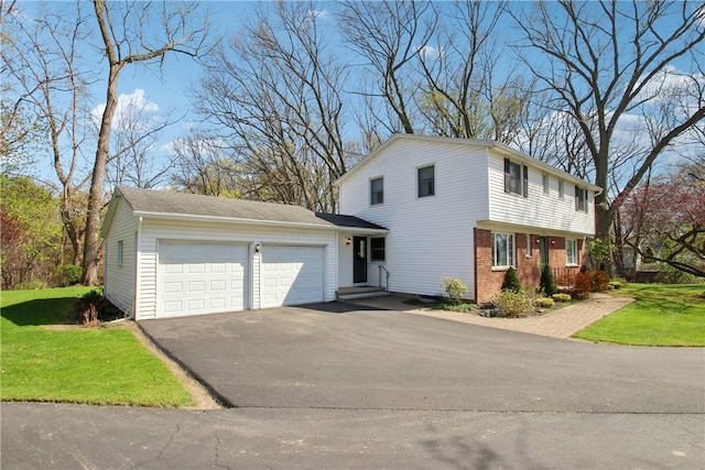 view of front of home with aphalt driveway, a garage, a front lawn, and brick siding