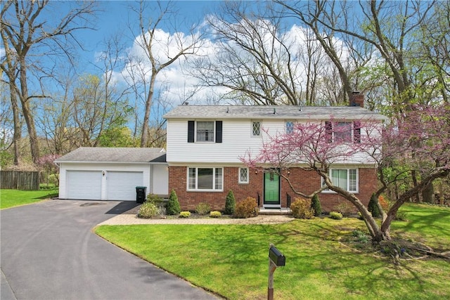 view of front facade featuring a chimney, driveway, brick siding, an attached garage, and a front lawn