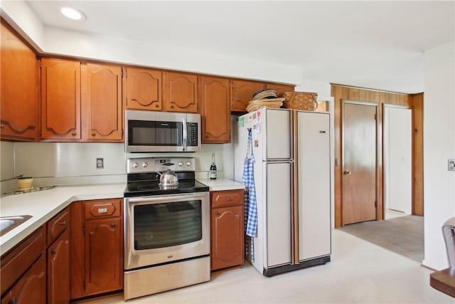 kitchen featuring brown cabinetry, light countertops, and stainless steel appliances