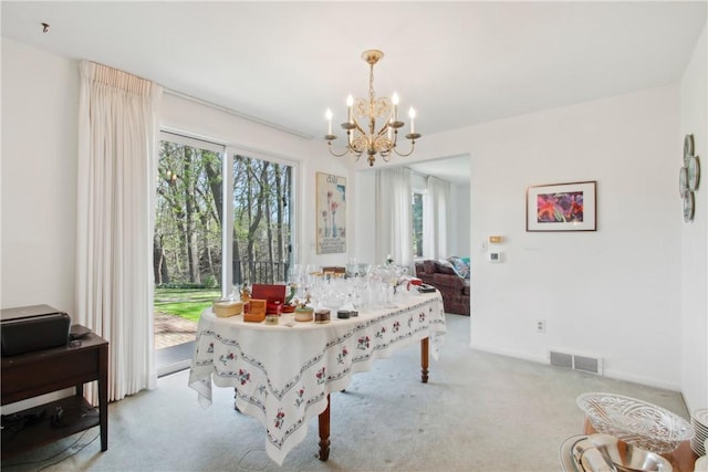 carpeted dining area featuring a chandelier and visible vents