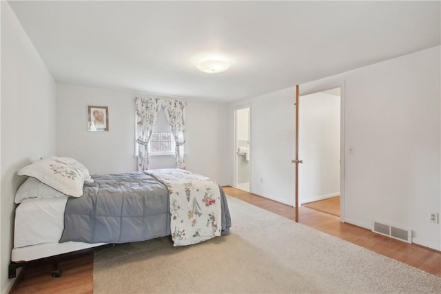 bedroom with visible vents and wood finished floors