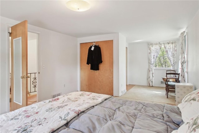 bedroom with a closet, visible vents, and carpet
