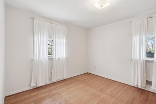unfurnished room featuring light wood-type flooring and baseboards