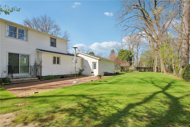 rear view of property with a yard and entry steps