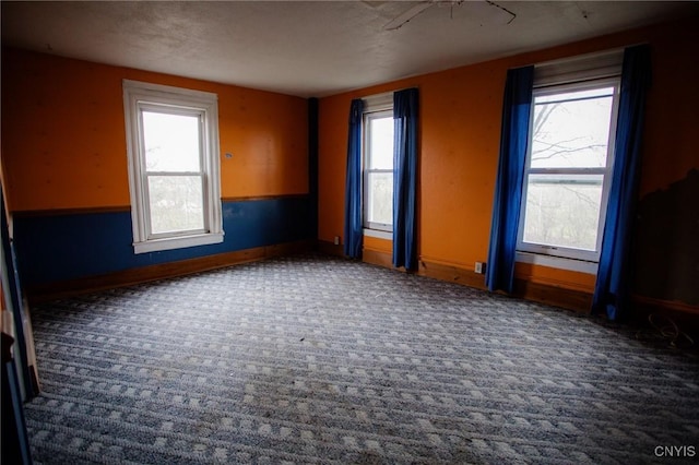 unfurnished room featuring baseboards, carpet flooring, and a healthy amount of sunlight