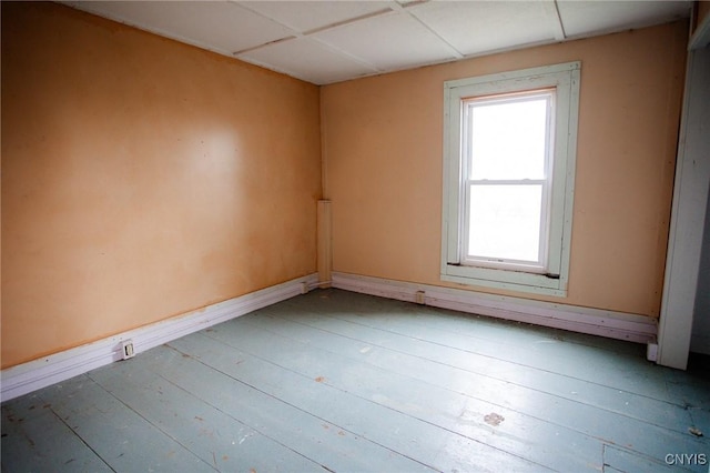 unfurnished room featuring wood-type flooring and baseboards