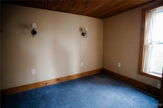 empty room with wood ceiling, baseboards, and carpet floors