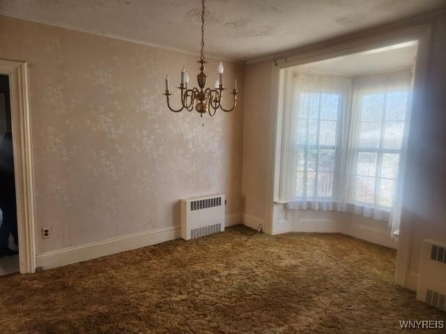 106 Saxton St, Lockport City, NY 14094 - unfurnished dining area with a notable chandelier, crown molding, carpet floors, and radiator heating unit