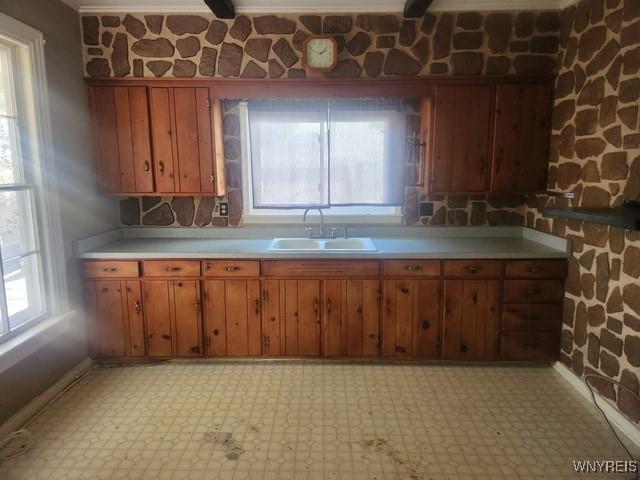 106 Saxton St, Lockport City, NY 14094 - kitchen featuring light countertops, light floors, brown cabinetry, and a sink
