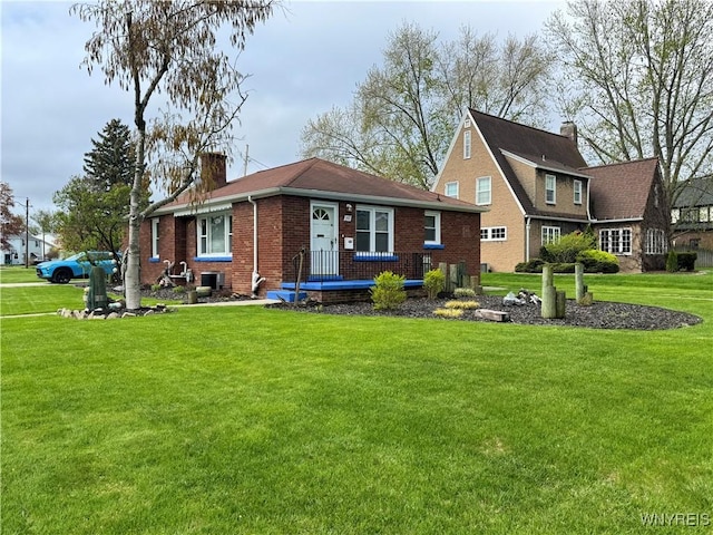 797 Van Rensselaer Ave, Niagara Falls, NY 14305 - view of front of home with brick siding, a front lawn, cooling unit, and a chimney