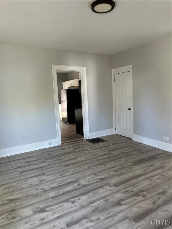 unfurnished room featuring baseboards and wood finished floors