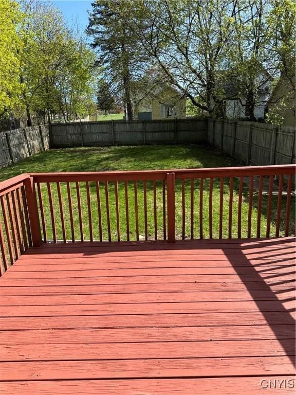 wooden terrace with a fenced backyard and a yard